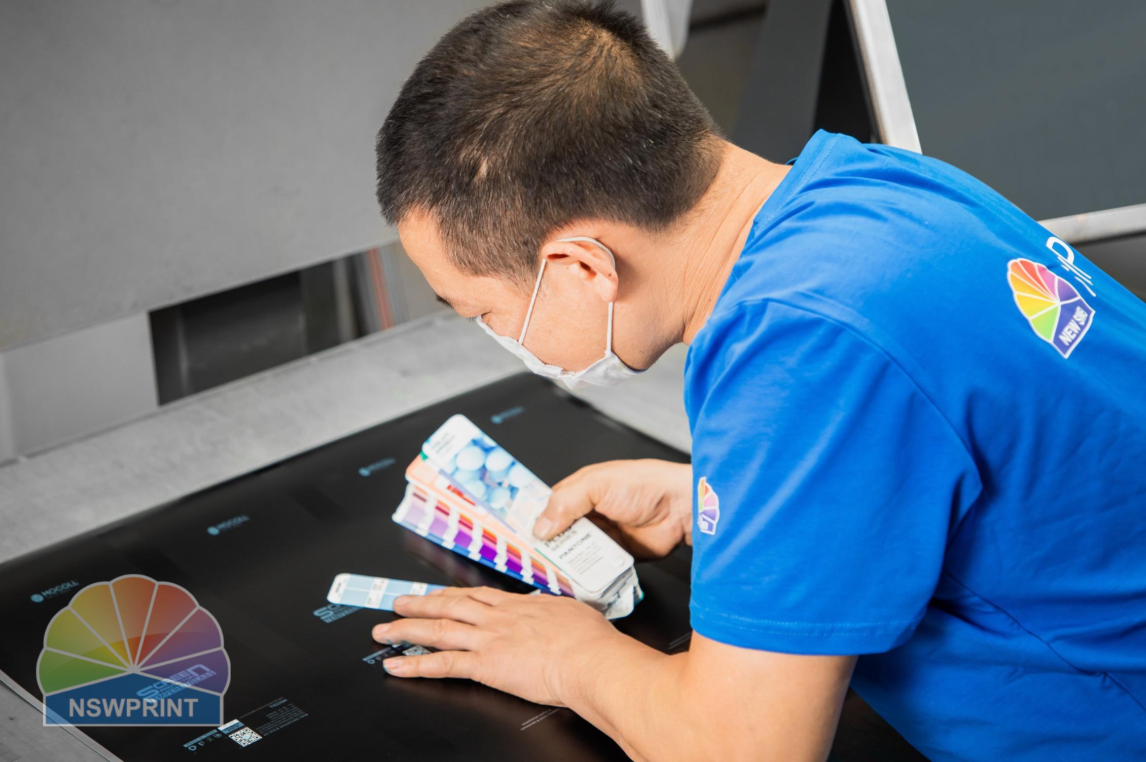 Factory operator monitoring custom packaging sheet printing